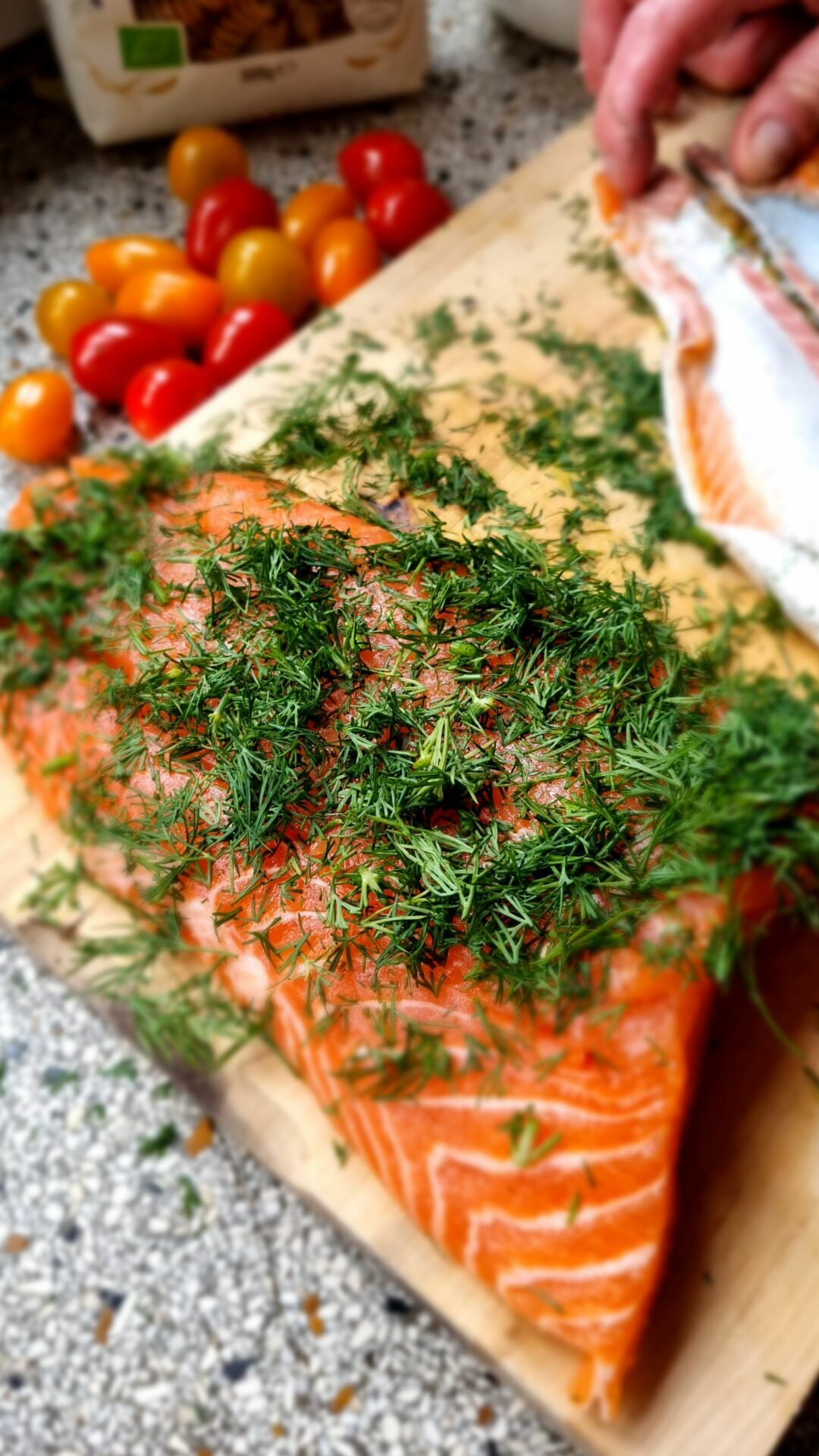 Filet de saumon cru recouvert d'aneth frais, prêt pour une cuisson douce