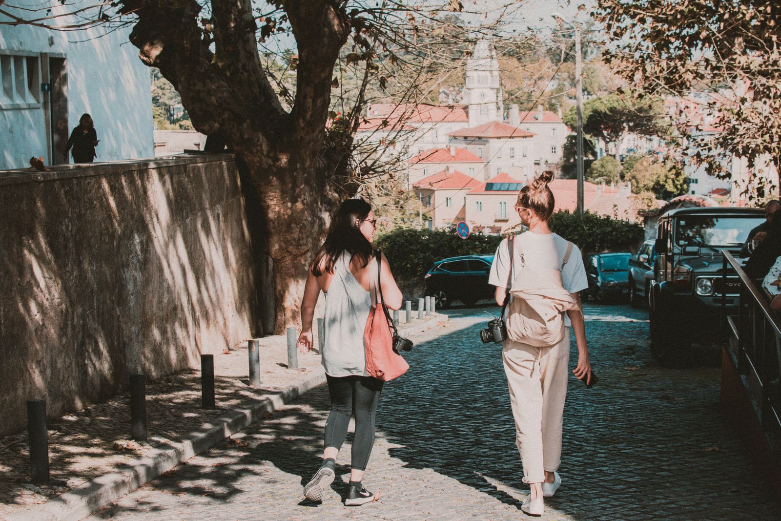 Deux femmes se promenant dans une rue ensoleillée, lien social et humeur