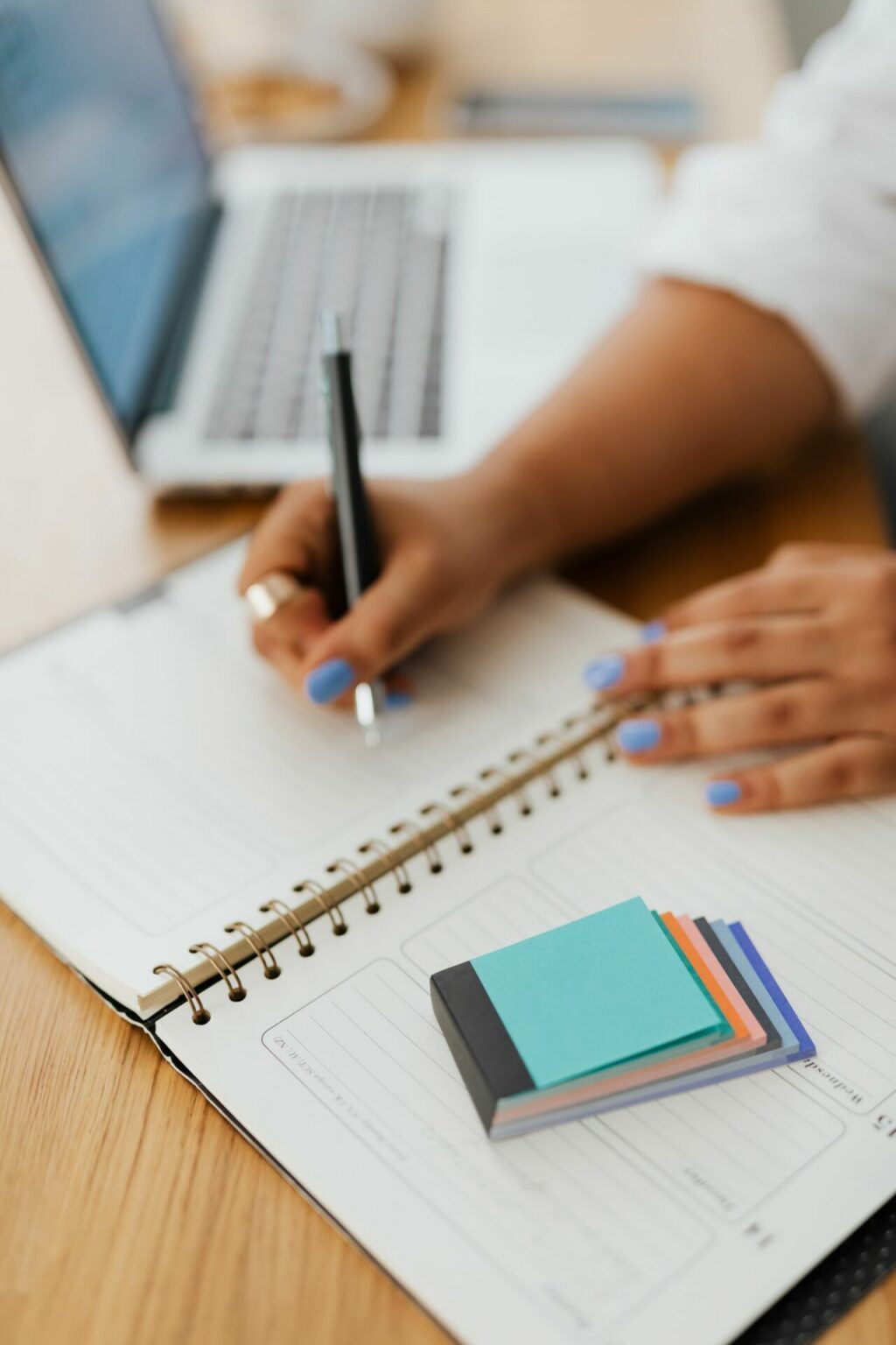 Main écrivant dans un carnet à spirale, organisation et attention au quotidien