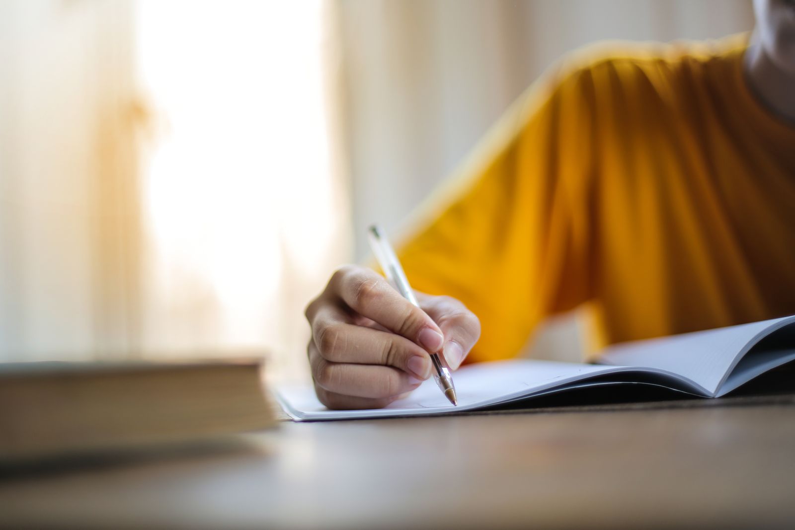 Main écrivant dans un carnet, suivi du cycle et des symptômes de la périménopause