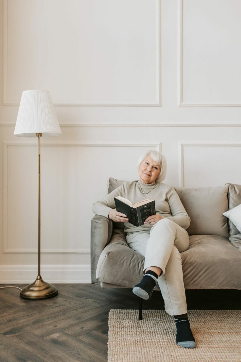 Femme aux cheveux blancs lisant dans un fauteuil, santé du cerveau après 50 ans