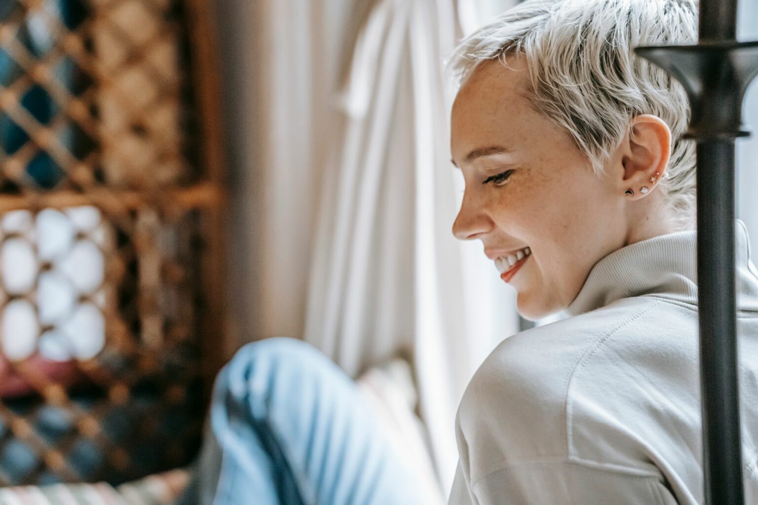 Femme aux cheveux gris souriante près d'une fenêtre, préserver son cerveau