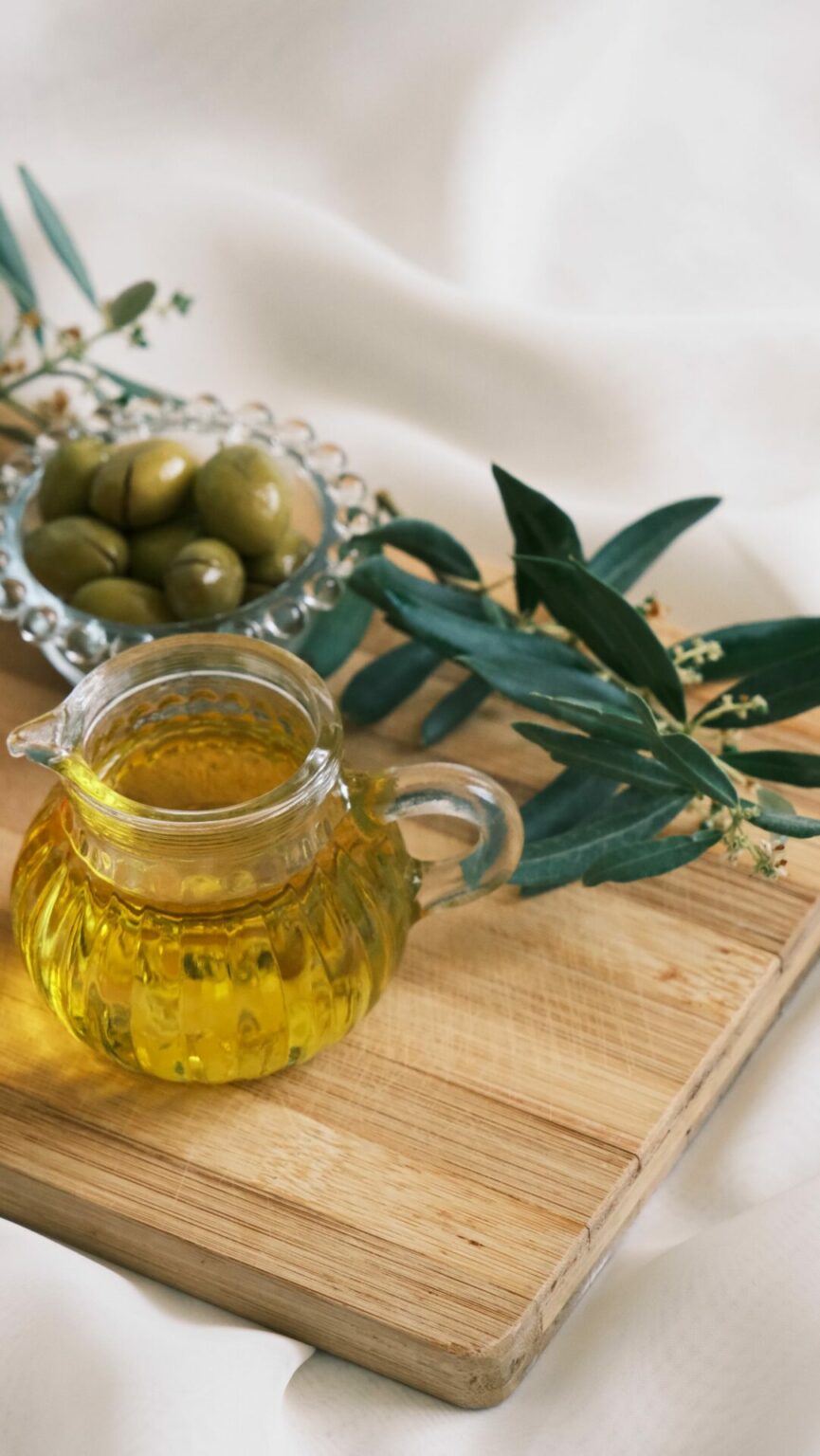 Huile d'olive et olives vertes sur une planche en bois, graisses alimentaires de qualité