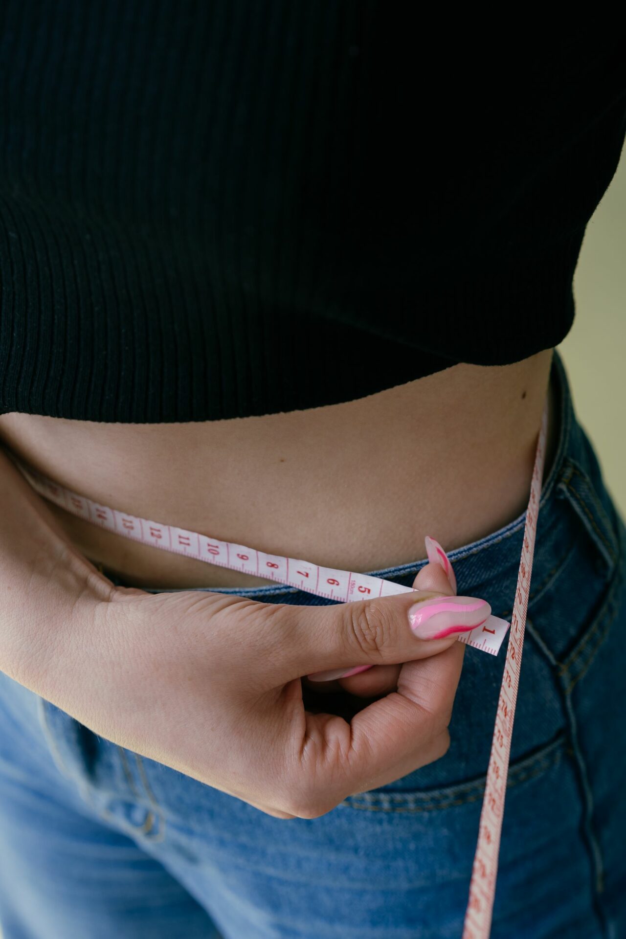 Femme mesurant son tour de taille avec un mètre ruban, repère de la graisse viscérale